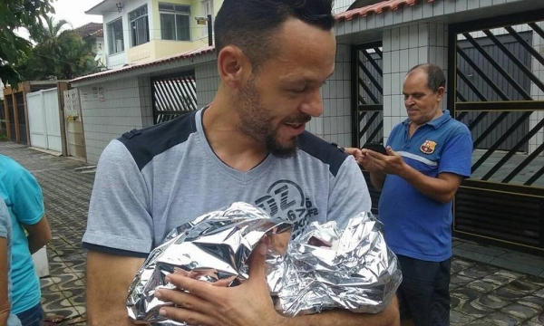 Xalaco com a pequena Mellany no colo, logo após o SAMU chegar no local (Foto: G1 Santos)